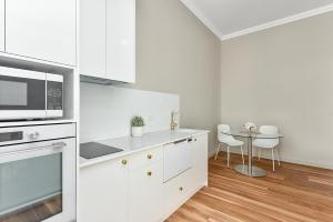 芒特甘比尔Aloha Central Platinum Apartments的白色的厨房配有微波炉和桌子