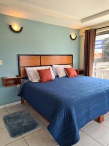 Paracho de VerduzcoHotel Santa Fe的一间卧室配有一张带红色枕头的大蓝色床