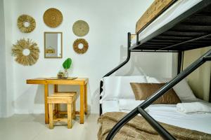 伊洛伊洛Pallet Homes - Gran Plains的一间卧室配有一张床和一张木桌