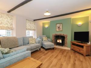 沃明斯特Granary Cottage的带沙发和壁炉的客厅