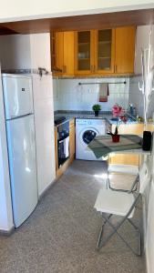 里斯本Lisbon Airport Guesthouse的厨房配有桌子和白色冰箱。