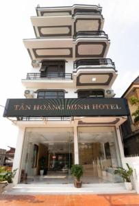 洞海Tan Hoang Minh Hotel的一座高大的白色建筑,上面标有酒店标志