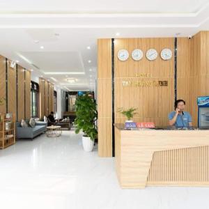 洞海Tan Hoang Minh Hotel的站在大厅柜台的女人