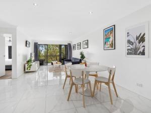 黄金海岸Luxury Stunning Nobby's Beach Home 2bd + Den !的白色的客厅配有桌椅