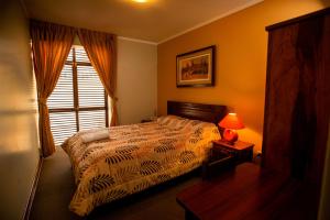 阿亚库乔里维拉酒店的一间卧室设有床、窗户和一盏灯。
