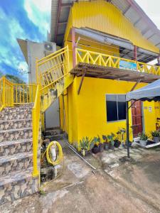 停泊岛Perhentian Sri Tanjung , Pulau Perhentian的黄色的房子,前面有黄色的楼梯