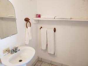 玉米岛Sunrise Hotel的浴室配有盥洗盆、镜子和毛巾