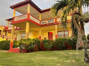 玉米岛Sunrise Hotel的带阳台的大型黄色和红色房屋