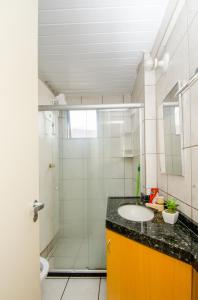 福塔莱萨Meireles Ana Bilhar的一间带玻璃淋浴和水槽的浴室