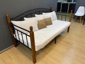 丹绒武雅Stylishly Spacious的一张带白色床单和枕头的床