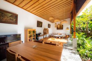 乌布Kubu Kirana by Supala的用餐室配有大型木桌和椅子