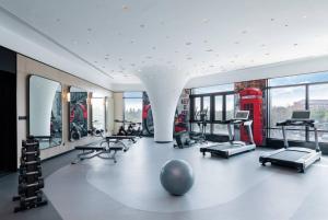 上海上海虹桥睿景酒店的健身房设有许多健身器材和红色电话亭