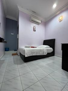 克提HOTEL RAUDHAH Kerteh的卧室配有1张床,铺有瓷砖地板。