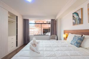 乌鲁班巴Town Center Apartments的卧室配有一张大白色床和窗户