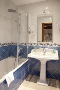 圣米歇尔山奥贝奇圣皮埃尔酒店的浴室配有水槽、淋浴和浴缸。