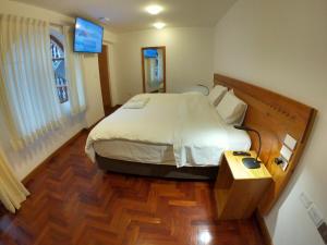 瓦拉斯Akilpo Home的一间卧室设有一张大床,铺有木地板
