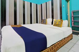 伦邦OYO 92269 Arjuna Homestay的一间卧室配有带白色床单和枕头的床。