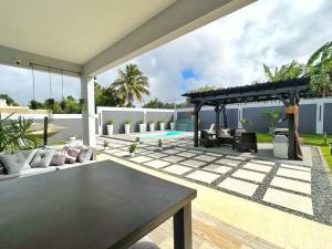 阿瓜迪亚The West House Pool Home in Aguadilla, Puerto Rico的客厅配有桌子和庭院。
