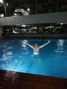 库库塔Apartamento en Cúcuta completó en condominio 17的男人晚上在游泳池游泳