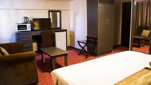 安曼Olive Hotel Amman的酒店客房配有两张床和一张带微波炉的书桌。