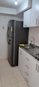 库库塔Apartamento en Cúcuta completó en condominio 17的厨房配有黑色冰箱和水槽
