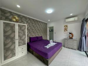 乔木提恩海滩VIEW TALAY VILLAs POOL 119, JOMTIEN BEACH, PATTAYA的一间卧室,在房间内配有一张紫色的床