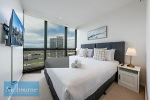 墨尔本墨尔本私人公寓 - 滨海港区科林斯街的一间卧室设有一张大床和大窗户