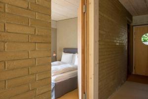 BelleriveGästehaus mit See- und Weitblick的卧室旁的砖墙,卧室配有床