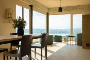 BelleriveGästehaus mit See- und Weitblick的一间带桌椅和窗户的用餐室