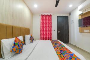 PrayagrajFabHotel The Comfort的一间卧室设有一张大床和一个窗户。