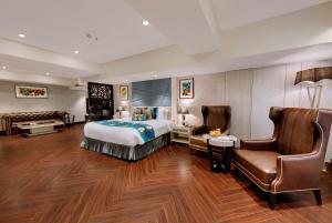西姆拉Marina- Shimla First Designer Boutique Hotel的配有一张床和一把椅子的酒店客房