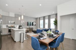 休斯顿Casa Azure - New Modern 3 BR, Med Center, NRG, UH的厨房以及带桌子和蓝色椅子的用餐室。