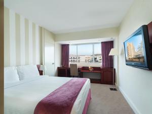 马斯喀特艾特肯斯彭斯酒店的配有一张床和一台平面电视的酒店客房