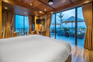 岘港Bonny Boutique Hotel Da Nang的一间卧室设有一张大床和一个大窗户