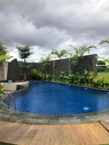 日惹Sawah Tamanan Villa & Resort的一个带木制甲板的大型蓝色游泳池