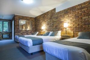 蒙特维尔Montville Mountain Inn的酒店客房带两张床和砖墙