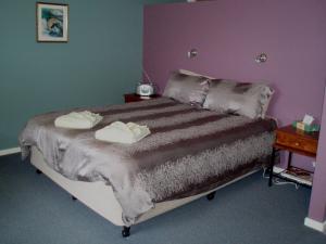 Bronte勃朗特公园高地小木屋和小屋公寓的一间卧室配有一张床,上面有两条毛巾