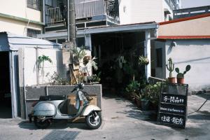 小琉球岛有一间森林民宿的停在植物建筑前面的摩托车