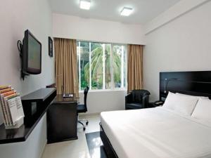钦奈Keys Select by Lemon Tree Hotels, Katti-Ma, Chennai的一间卧室配有一张床、一张书桌和一台电视。
