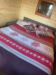 杜柏La Rouloulotte的小屋内的一张床位,配有红色毯子和枕头