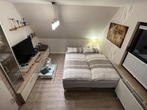 施塔德Peedy's luxuriöse 60m² Wohnung mit Balkonterrasse的一间小卧室,配有一张床和电视