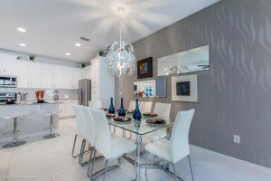 奥兰多Solara Resort - 5 Bed 4,5 Baths TOWNHOME的一间设有玻璃桌和白色椅子的用餐室