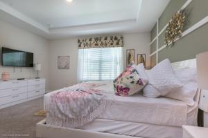 奥兰多Solara Resort - 5 Bed 4,5 Baths TOWNHOME的一间卧室配有带枕头的床铺和电视。