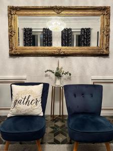 卡尔卡松SalutBB Chambre d'hote的镜子、两把蓝色椅子和枕头