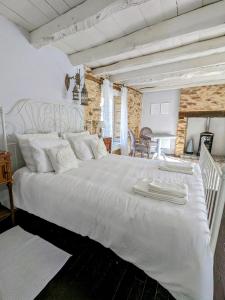 Jumilhac-le-GrandSous le Chateau的卧室配有白色大床和白色枕头