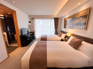 京都Rinn Gion Hanatouro的酒店客房设有两张床和电视。