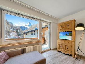 采尔马特Eagle apartment with splendid and direct view of the Matterhorn的客厅设有大窗户和电视。