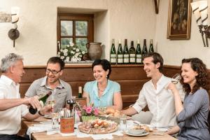 瓦豪地区魏森基兴Gästehaus Turm Wachau的一群坐在桌边喝葡萄酒的人