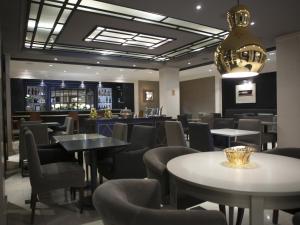 巴塞罗那巴尔莫勒尔酒店的一间带桌椅的餐厅和一间酒吧