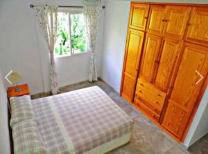 塔扎克蒂Apartamento El Tejar的一间卧室配有一张床、一个梳妆台和一扇窗户。